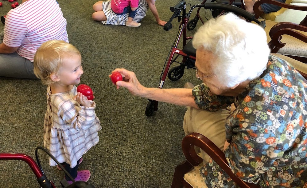 Young children and senior grand friends making music together at a Music with Grandfriends class